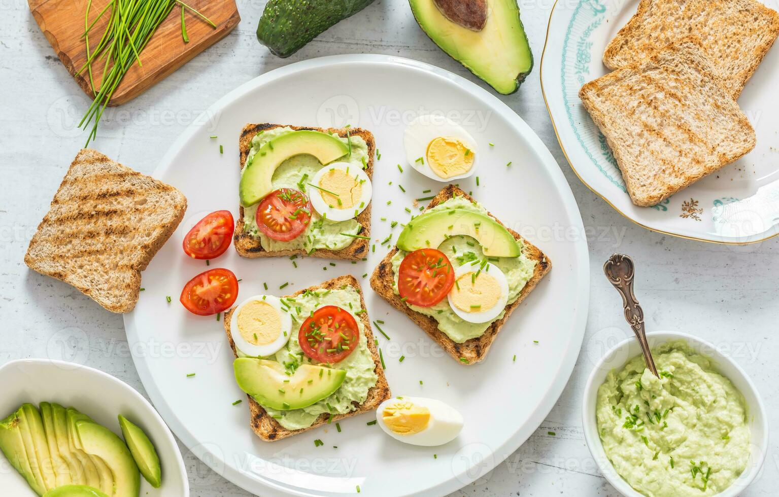 Healthy breakfast from toasts with avocado spread guacamole egg tomato and chives. photo