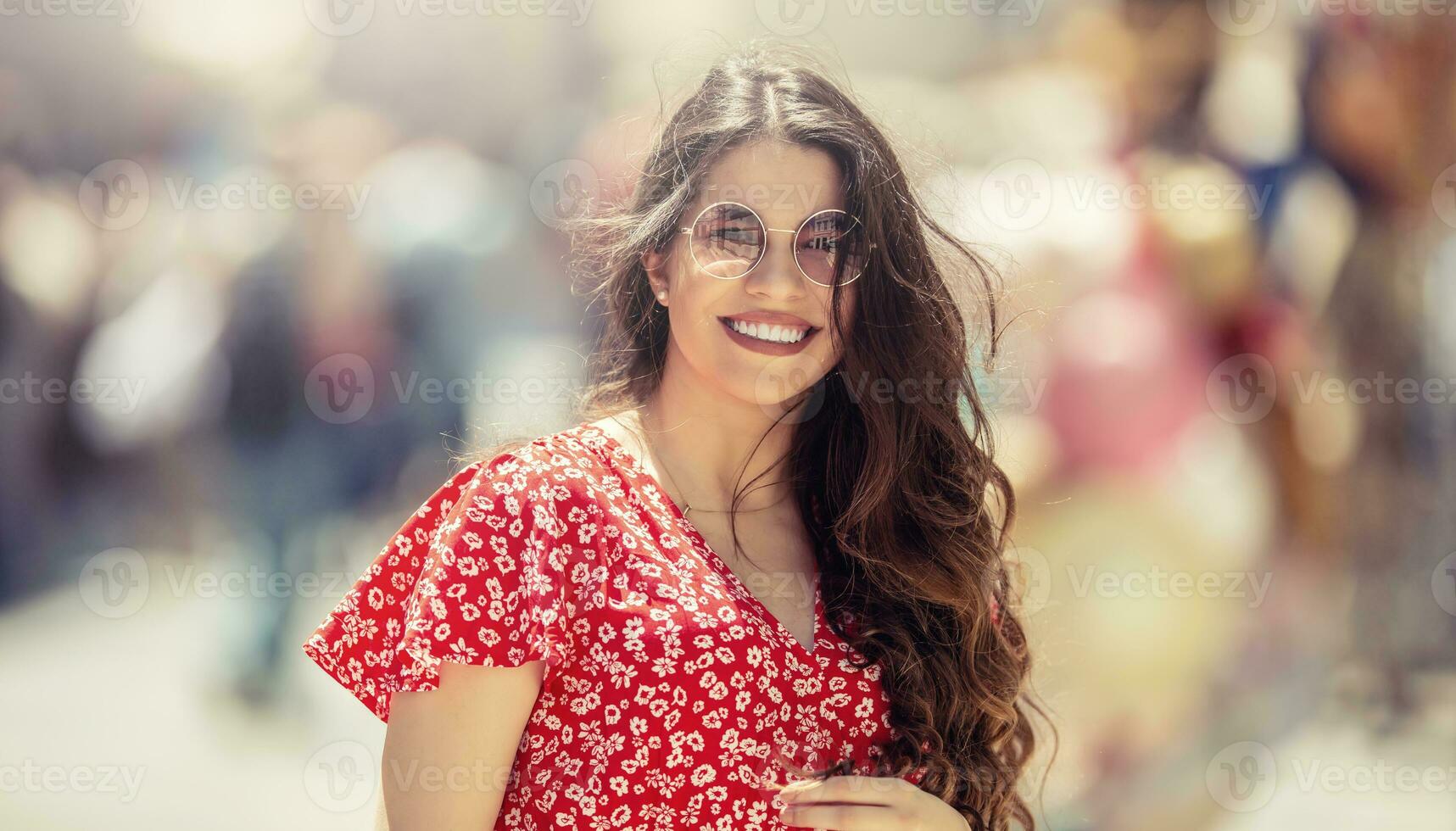 Summer portrait of a young beautiful woman in the city with the wind in her hair photo