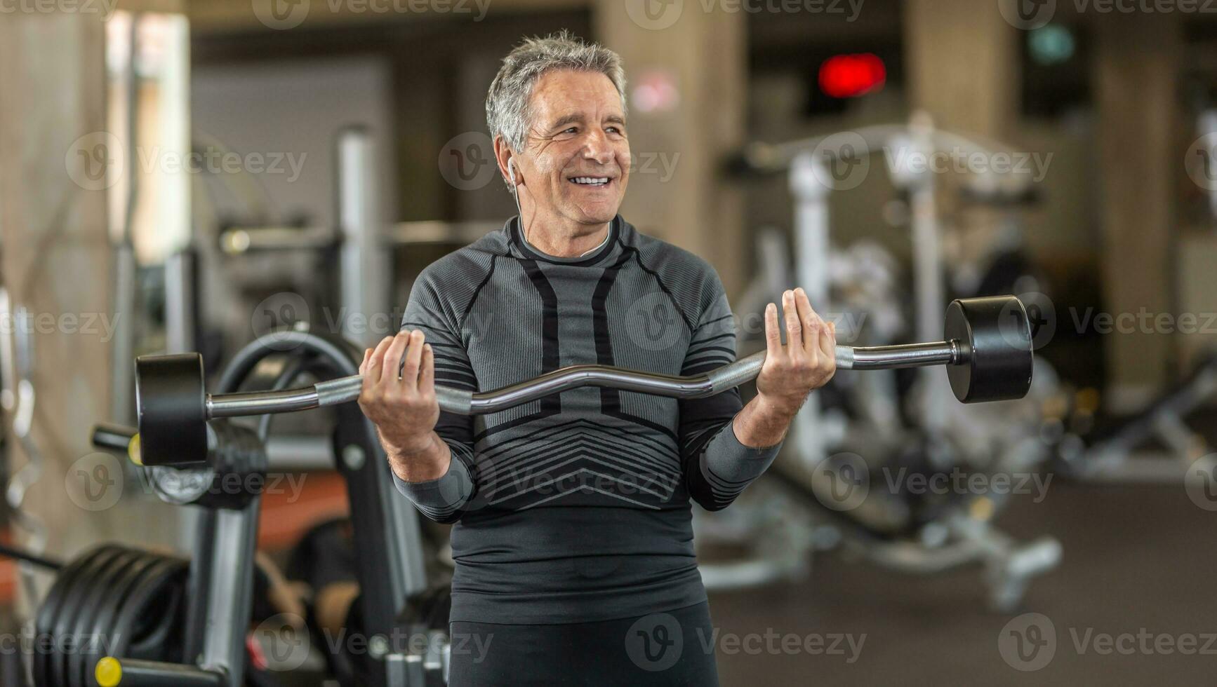 hombre en gris pelo tracción pesos dentro el gimnasio foto