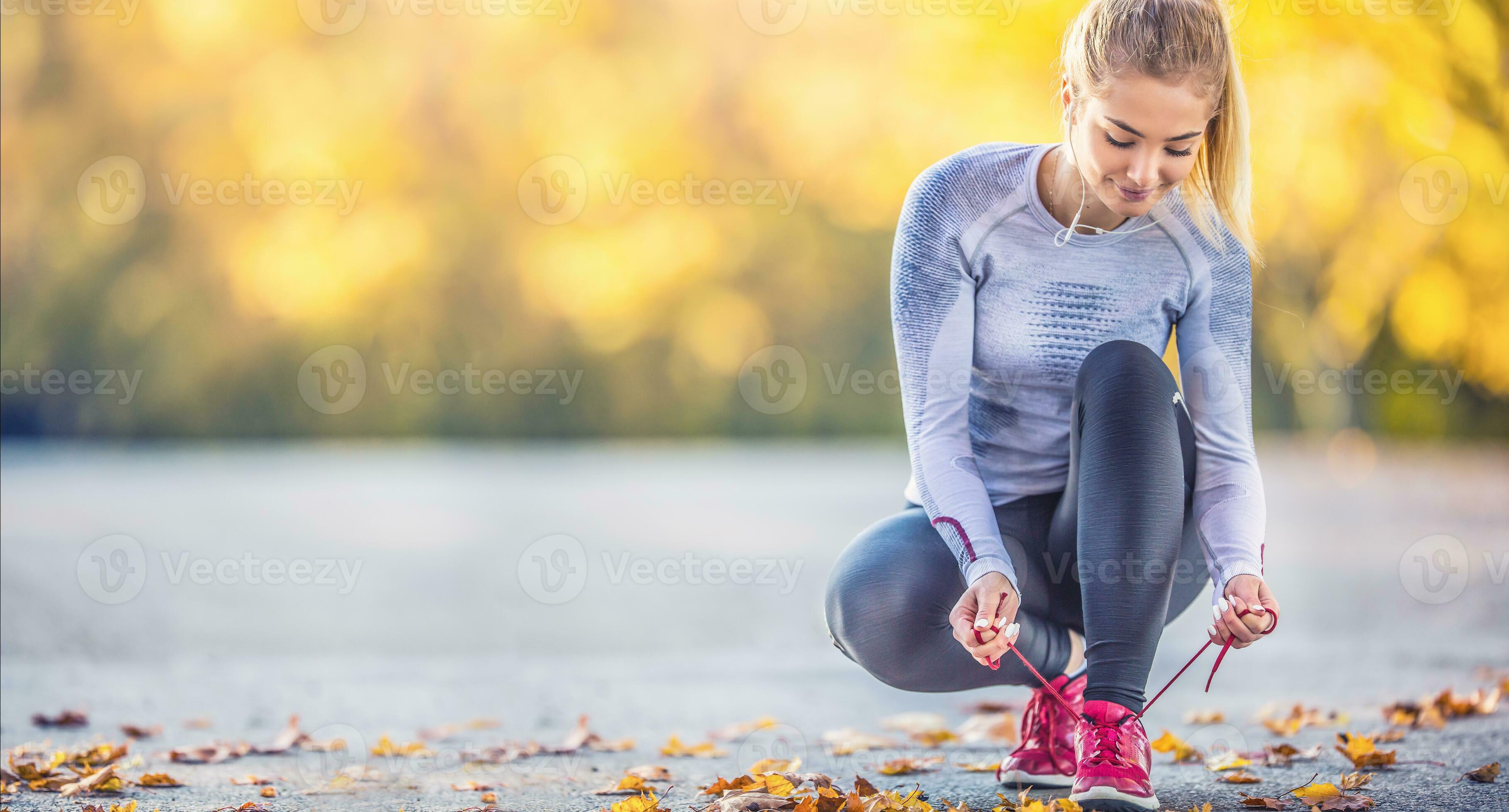 Woman runner tying shoelaces before jogging in autumn tree alley park.  Sports female autumn outfit leggings and thermal underwear 27548974 Stock  Photo at Vecteezy