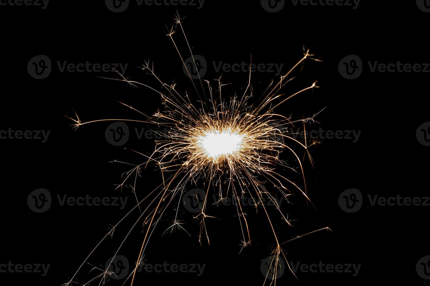 Burning sparkler isolated on black background. Fireworks theme. Light effect and texture. photo