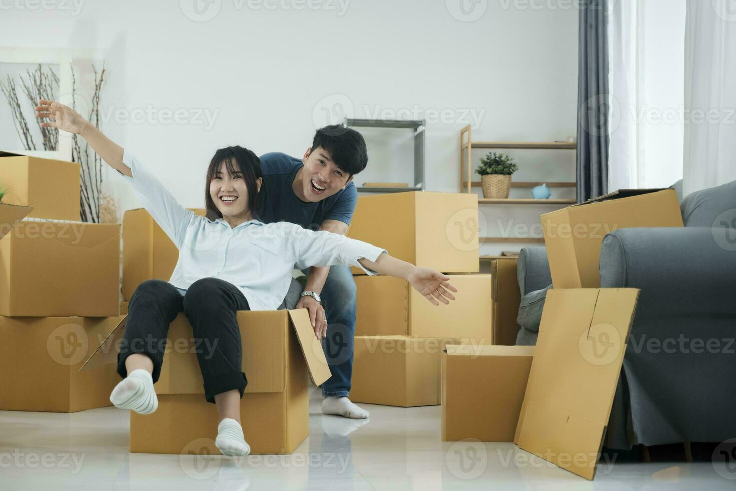 contento Pareja es teniendo divertido con cartulina cajas en nuevo casa a Moviente día. foto