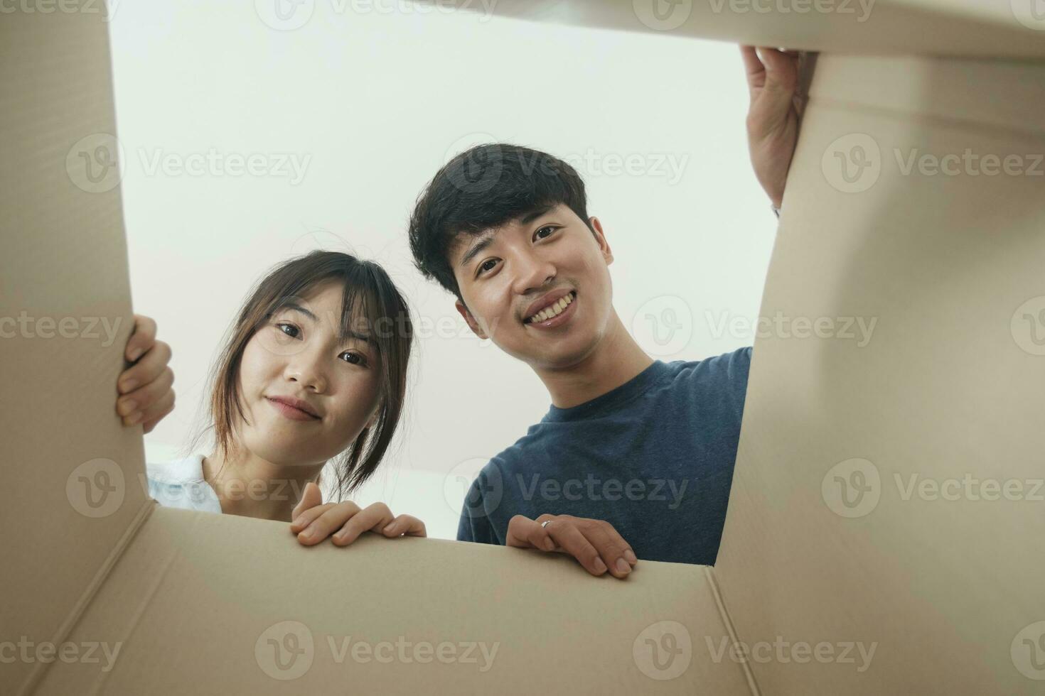 asiático joven contento nuevo casado Pareja Moviente a su nuevo casa o real bienes. foto