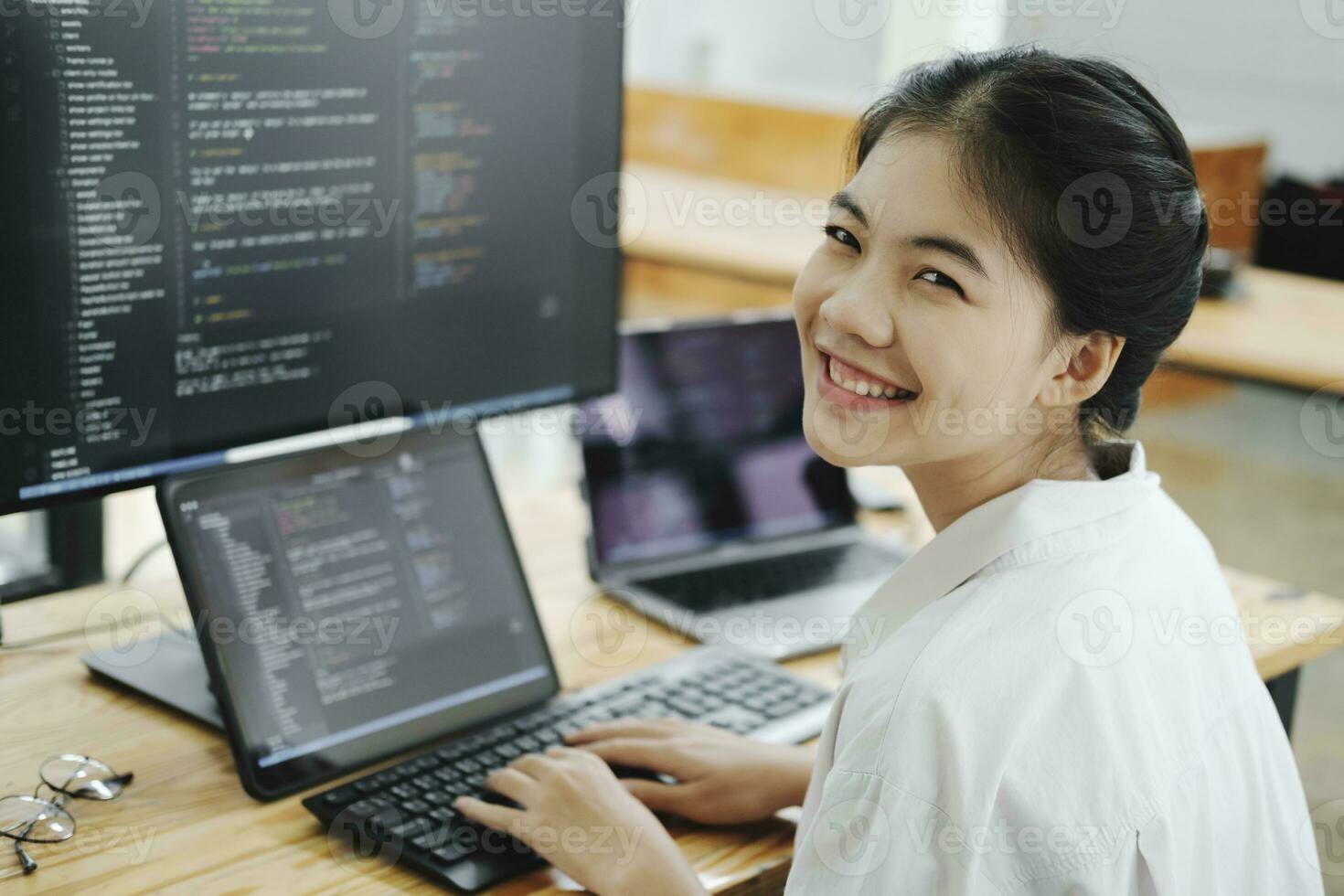 Young programmer working on desktop PC in office of software company. photo