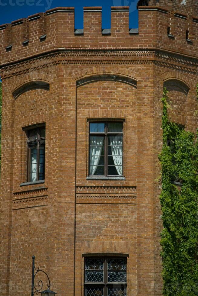 polaco histórico ladrillo palacio en rzucewo rodeado por verano verdor foto