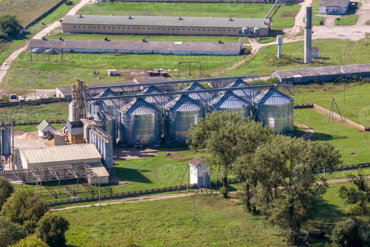 aerial panoramic view on agro-industrial complex with silos and grain drying line for drying cleaning and storage of cereal crops photo