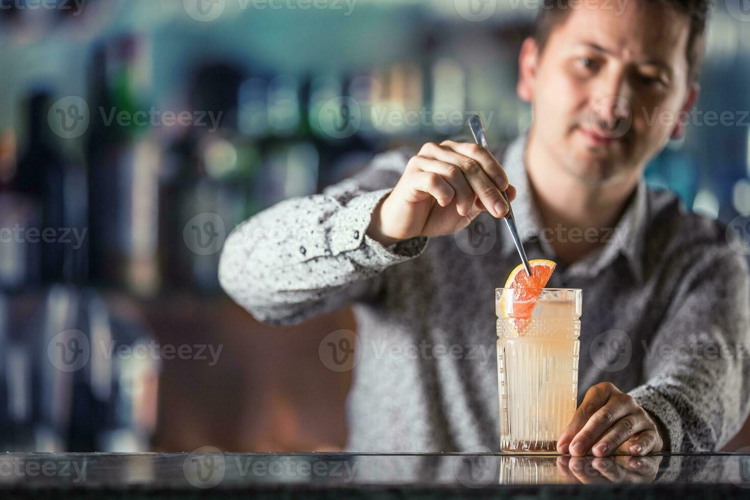 Professional barman making  alcoholic cocktail drink paloma photo