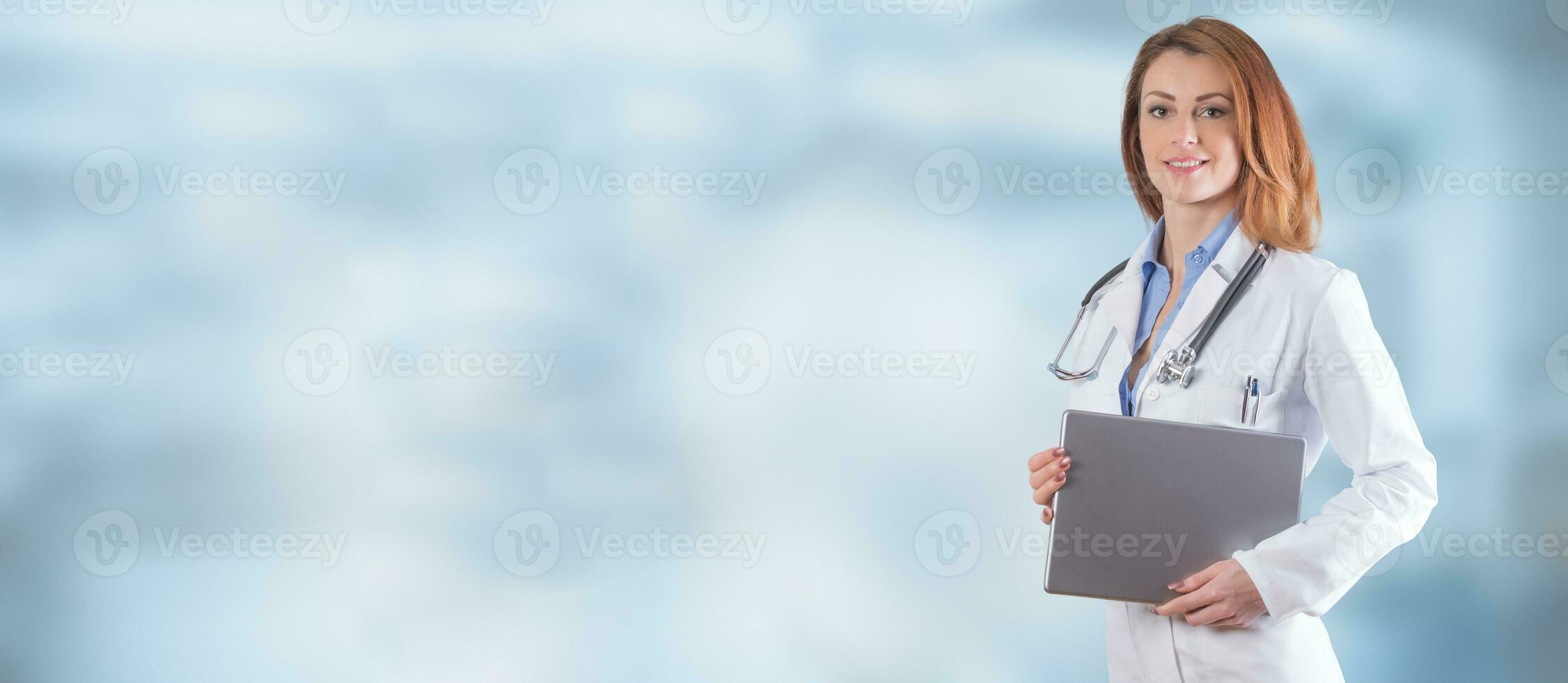 Portrait of a beautiful woman doctor with tablet over blue background. photo