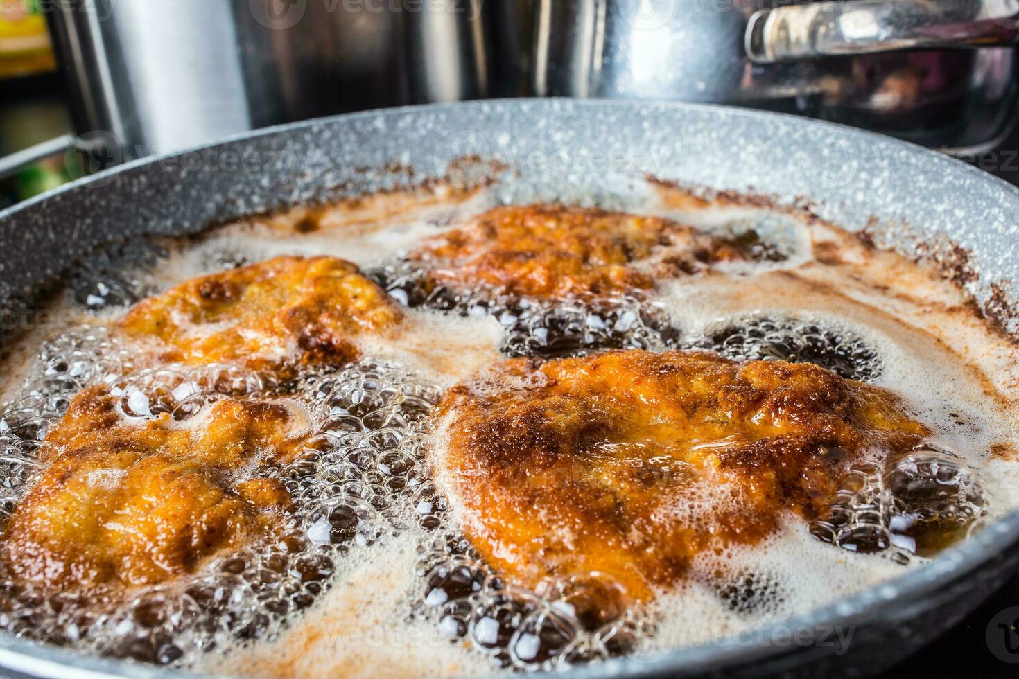 Pan with fried schnitzels in frying oil. photo