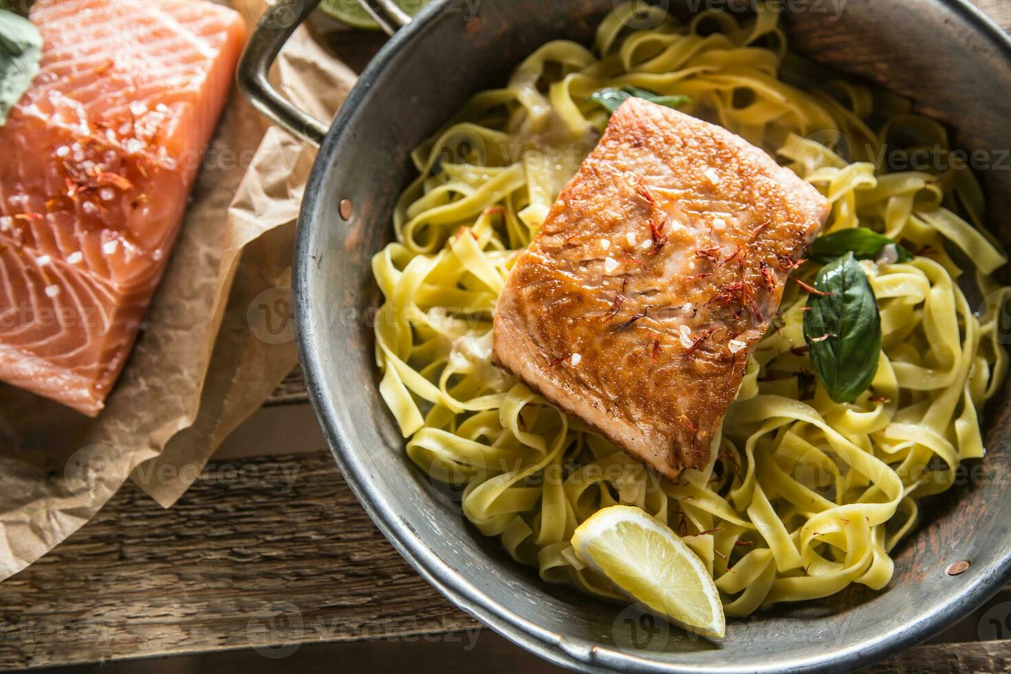 Roasted salmon fillet with pasta tagliatelle lemon and basil. photo