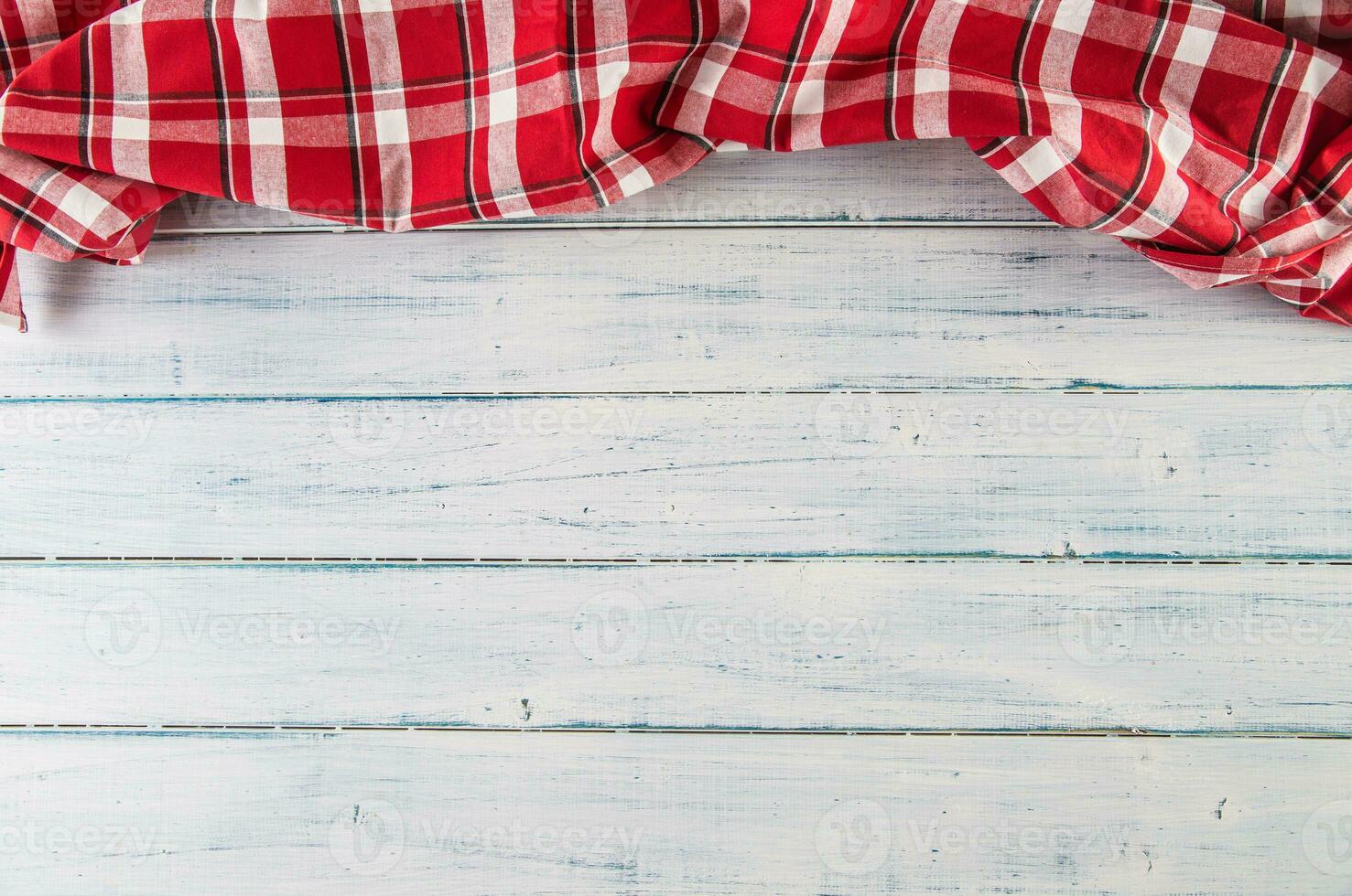 Top of view red checkered tablecloth on wooden table photo