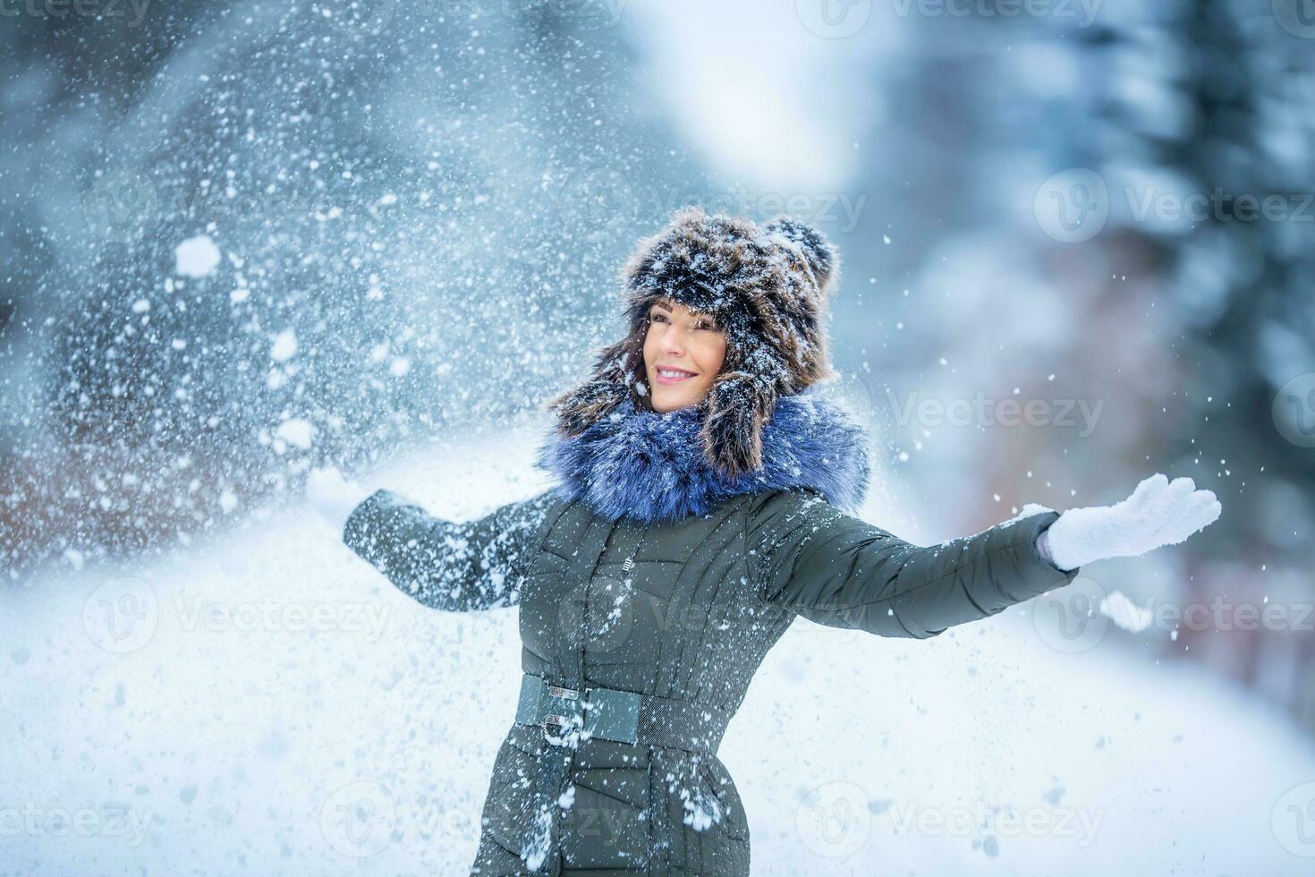 Beautiful smiling young woman in warm clothing. The concept of portrait in winter snowy weather photo