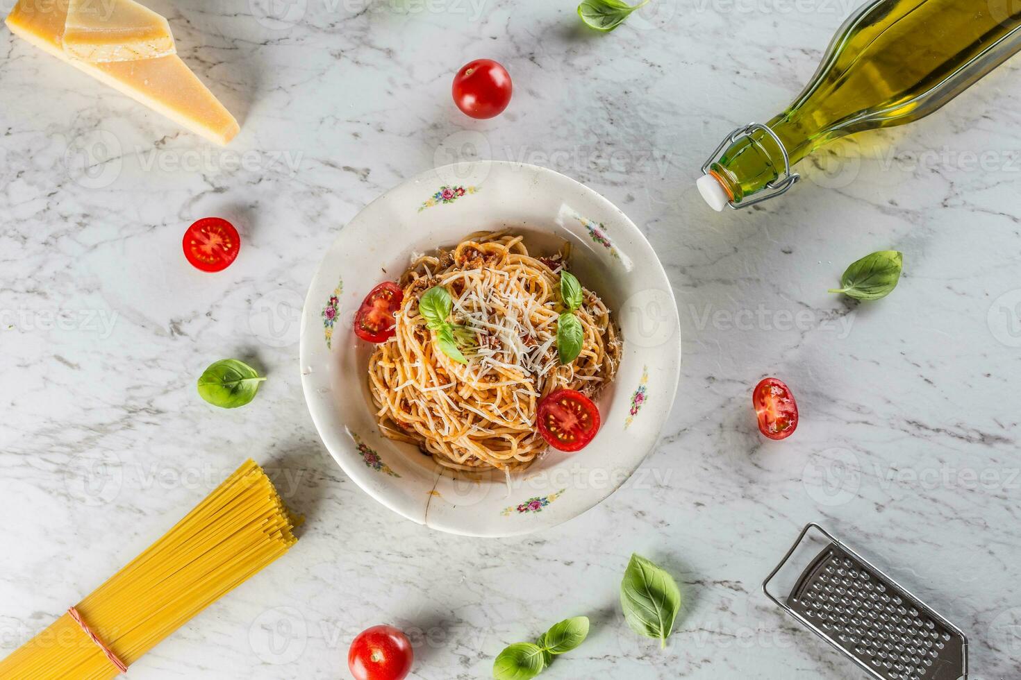 Spaghetti bolognese with ingredients basil tomatoes parmesan cheese and olive oil photo
