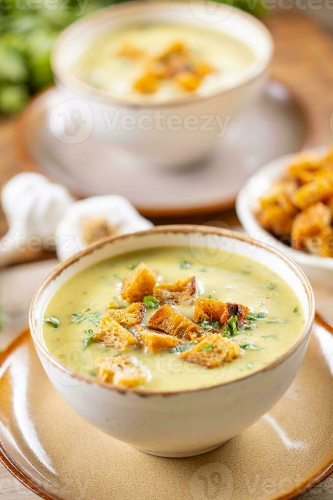 Garlic cream soup with bread croutons in rustic bowl photo