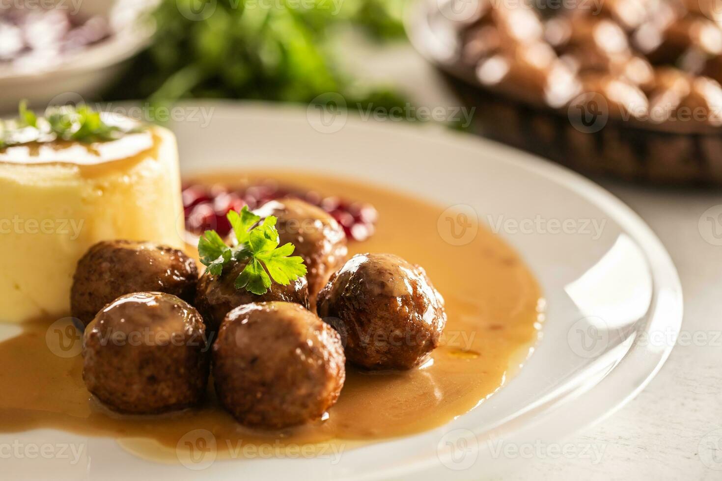 Plate serving Swedish meatballs kottbullar in sauce with mashed potatoes and cranberry sauce photo