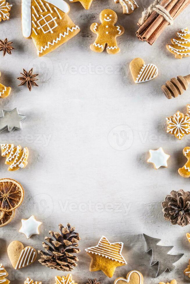 Christmas gingerbread cookies lie on the table together with cinnamon and pine cones. photo