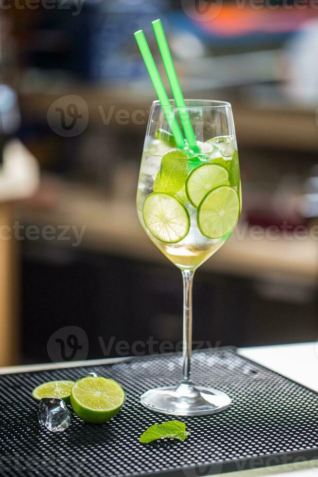 Cocktail drink or lemonade with cucumber on barcounter photo