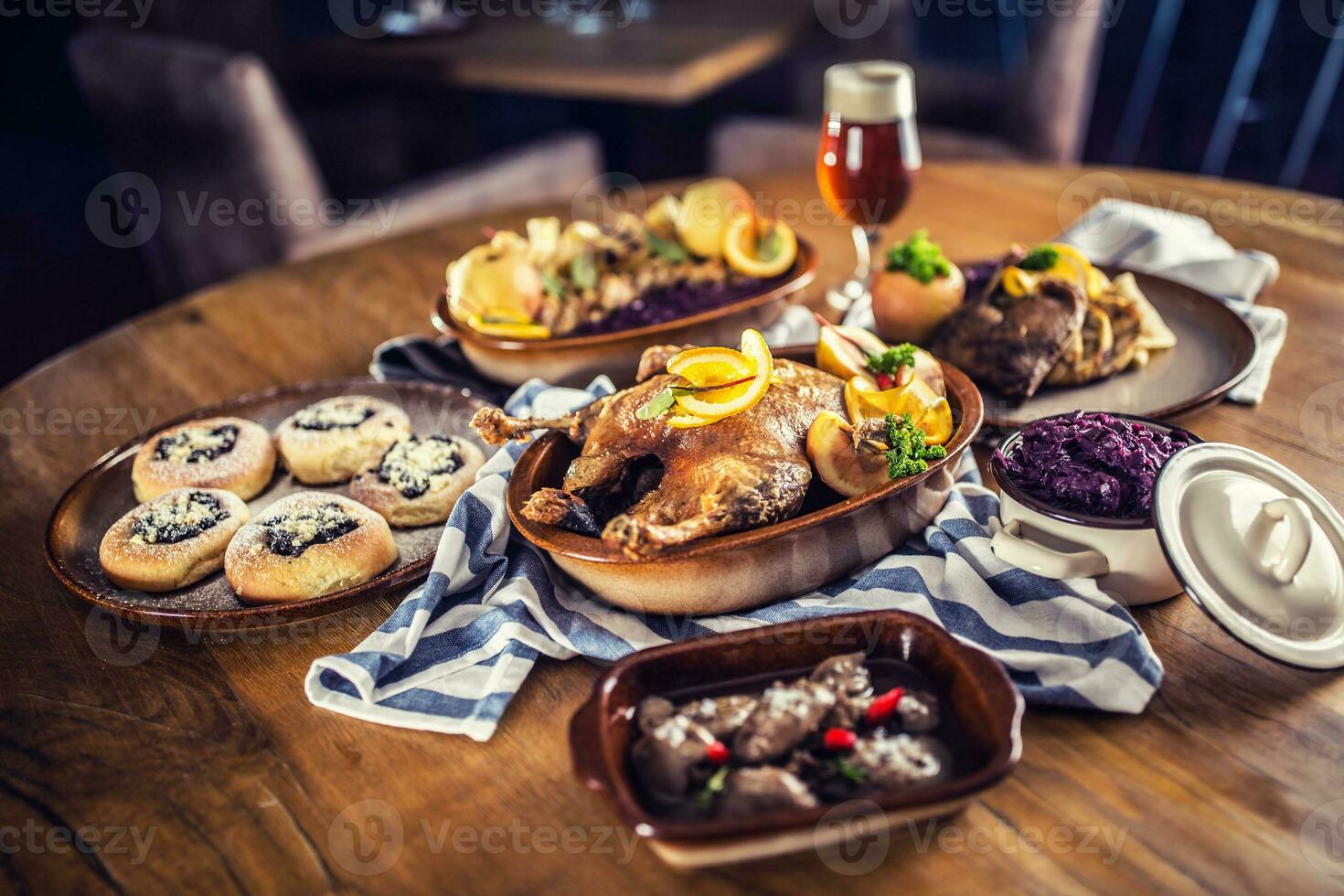 Roasted christmas duck red cabbage dumplings liver draft beer and baked buns. photo