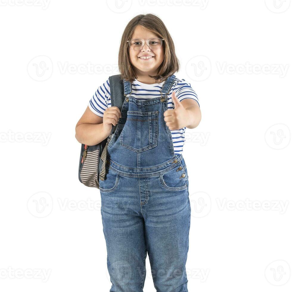 School attending girl wears backpack and shows thumb up expression on an isolated white background photo