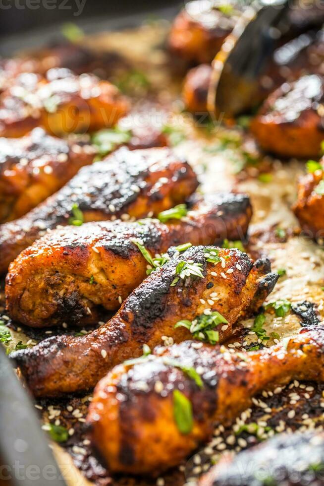 A la parrilla gallina piernas barbacoa con especias hierbas y sésamo en horneado papel. asado aves de corral comida en tostador plato foto