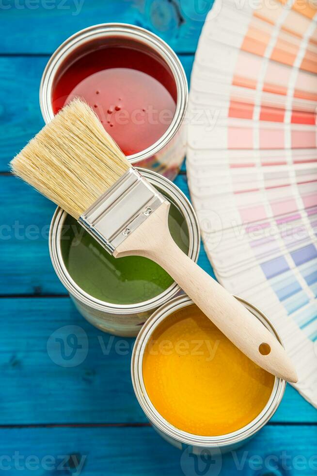 pintar latas color paleta, latas abrió con cepillos en azul mesa foto
