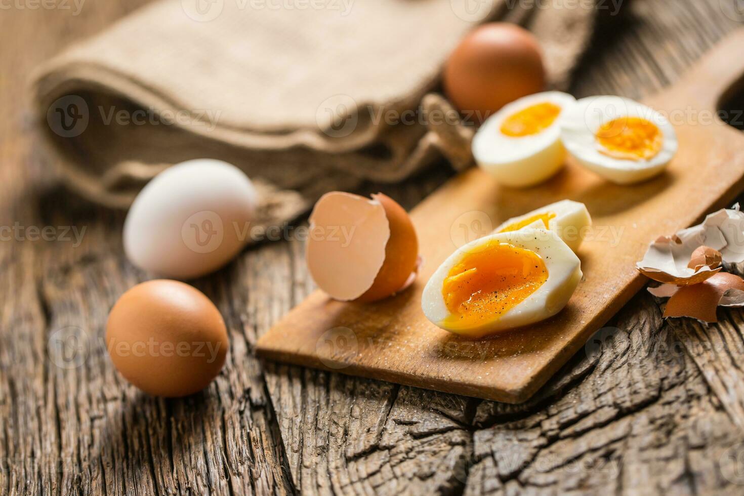 Close-up boiled or raw chicken eggs on wooden board photo