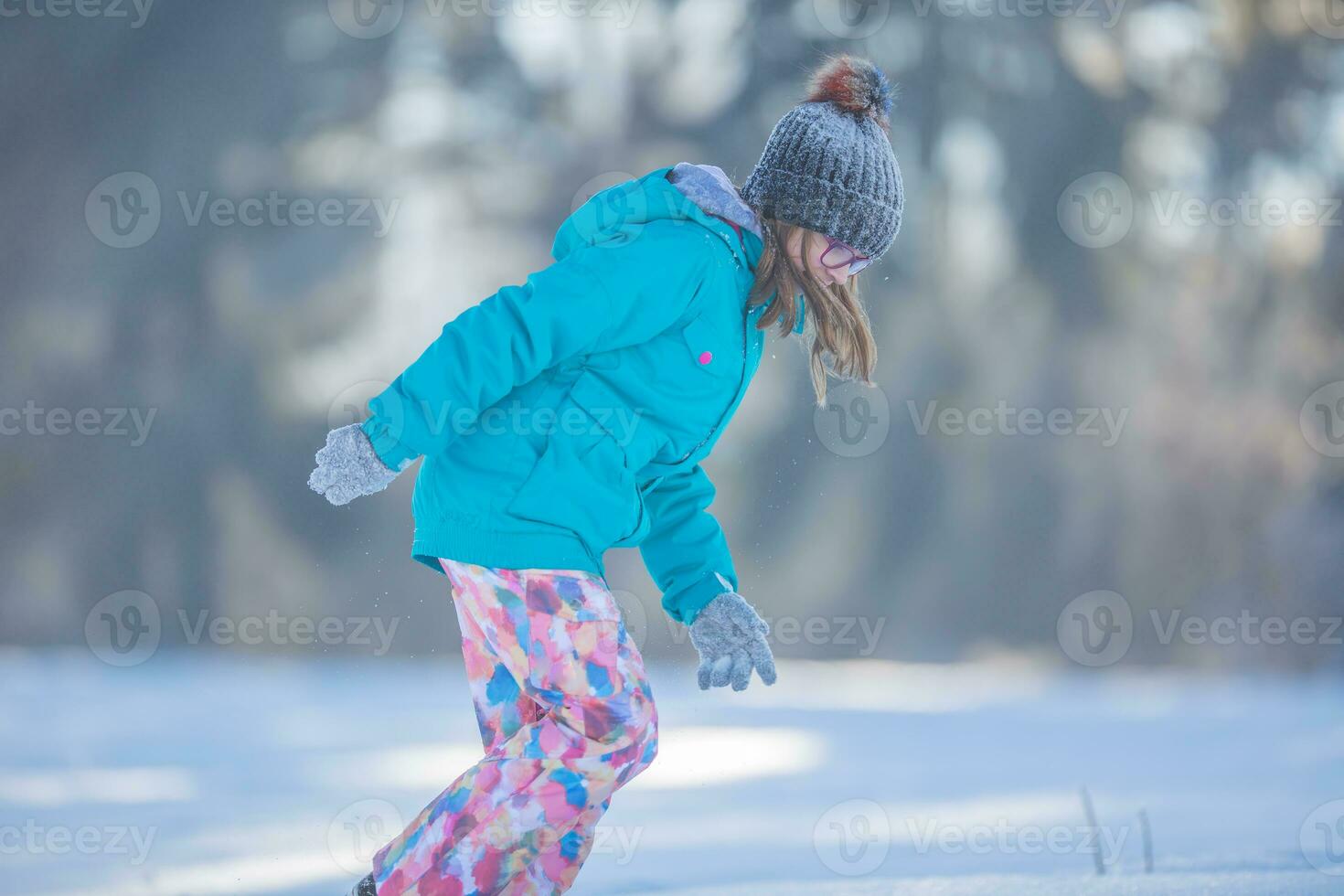 contento joven preadolescente niña en calentar ropa jugando con nieve foto