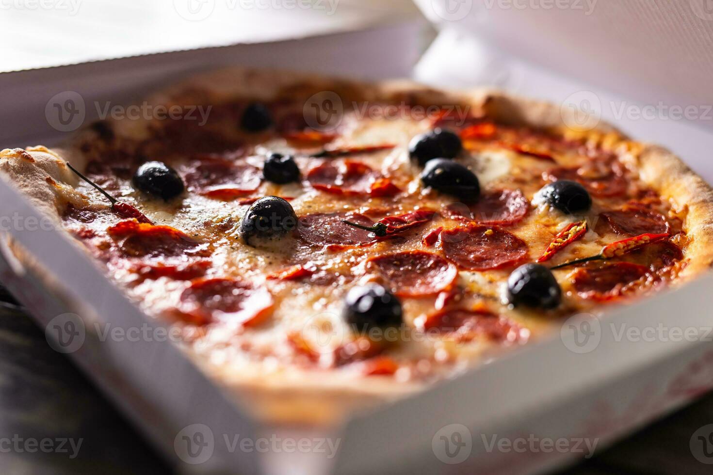 Pizza in a cardboard box on table ready to customer. photo