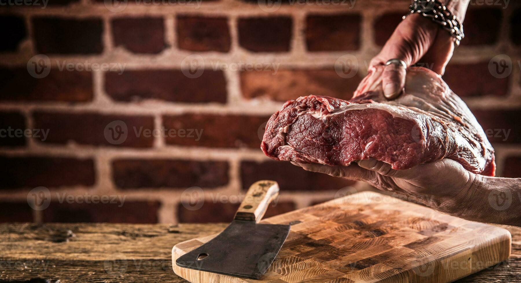 Carnicero hombre manos participación crudo carne de vaca filete en carnicería. foto