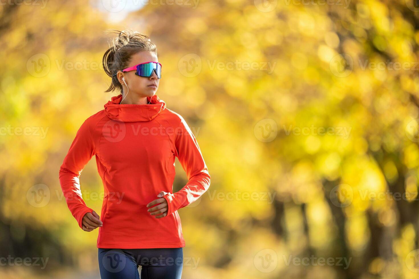 joven hembra atleta en ropa de deporte carreras en el parque durante calentar indio verano foto