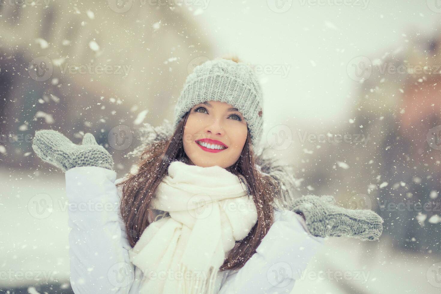 Beautiful smiling young woman in warm clothing. The concept of portrait in winter snowy weather photo