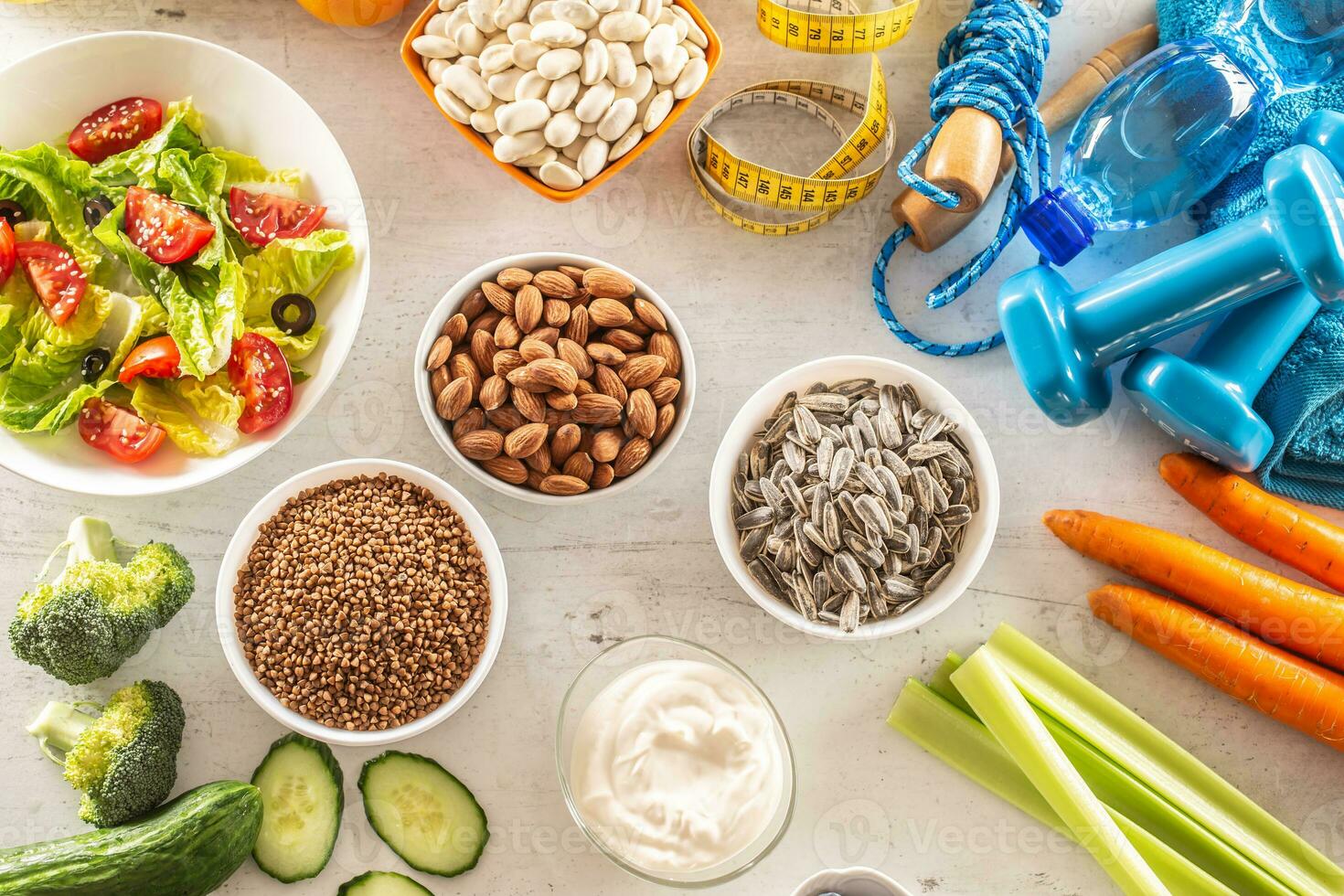 selección de sano alimentos, verduras, frutas, Almendras, ensalada, ejercicio herramientas y medición cinta foto