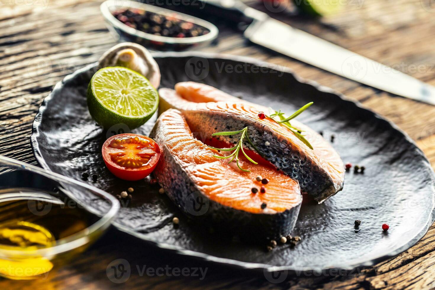 salmón crudo filetes Romero Tomates seta Lima aceituna petróleo y especias foto