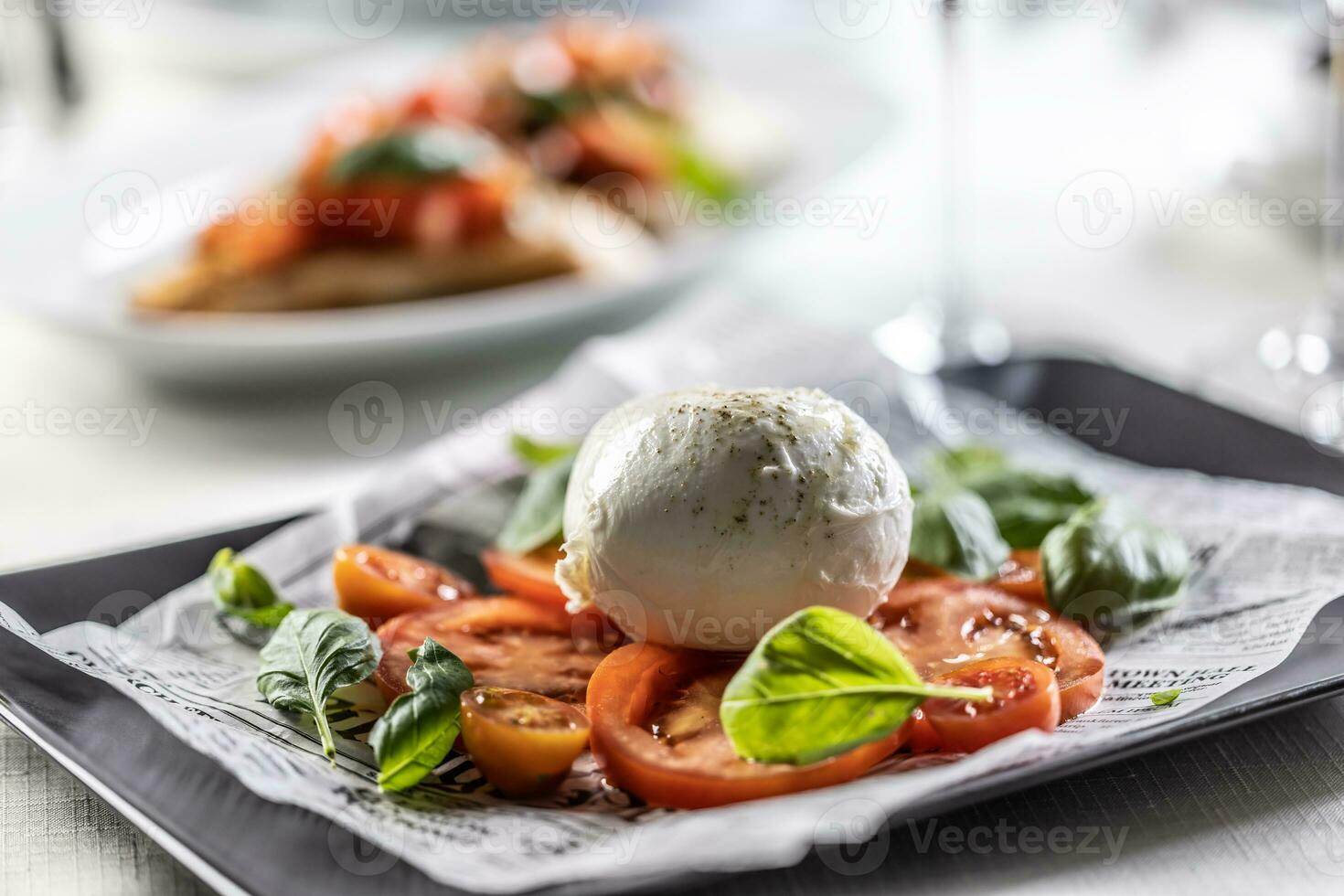 Caprese style salad with sliced tomatoes, basil and ball of buffalo mozzarella. photo