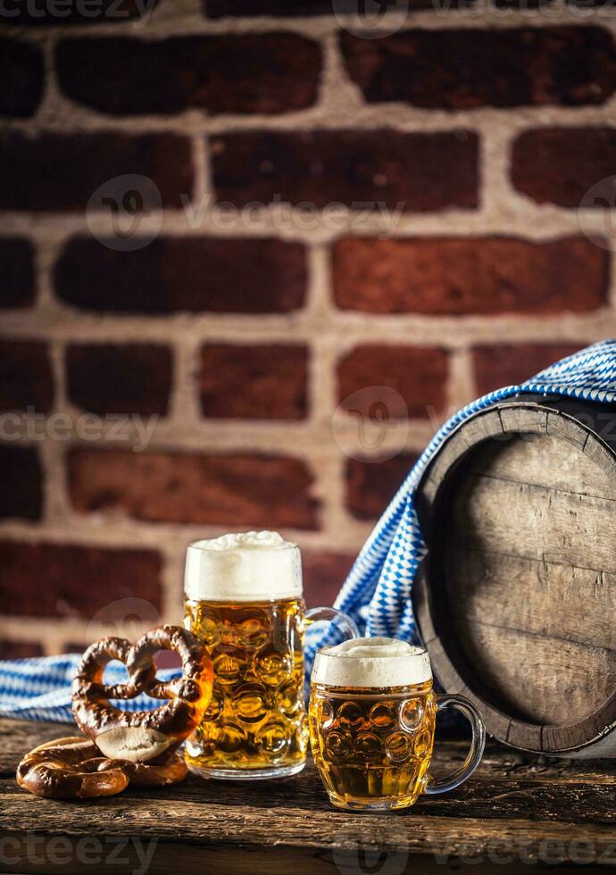 Oktoberfest large and small beer with pretzel wooden barrel and blue tablecloth photo