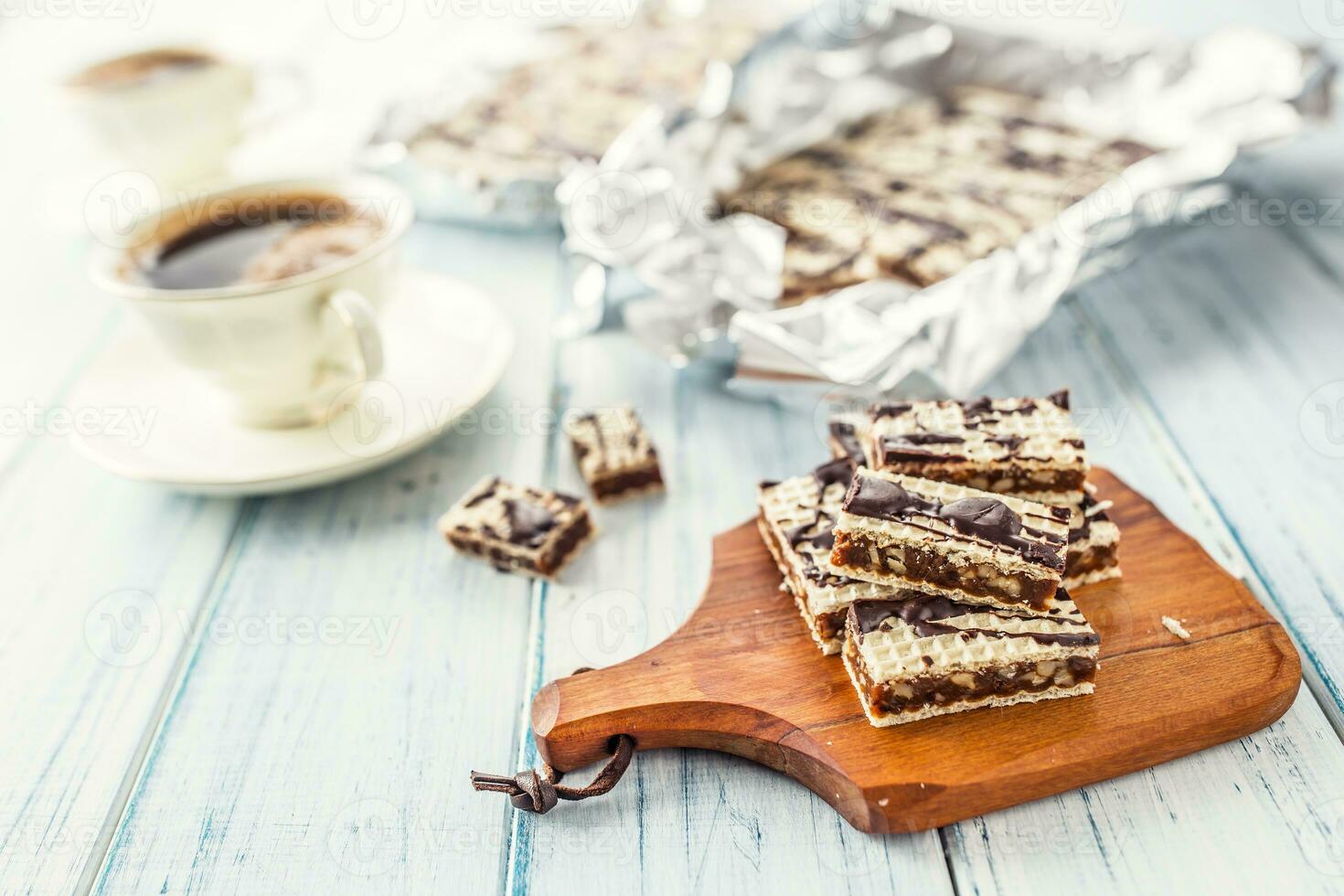 A waffle cake with caramel chocolate and walnuts.Traditional slovak and czech cake grilaz with coffee photo