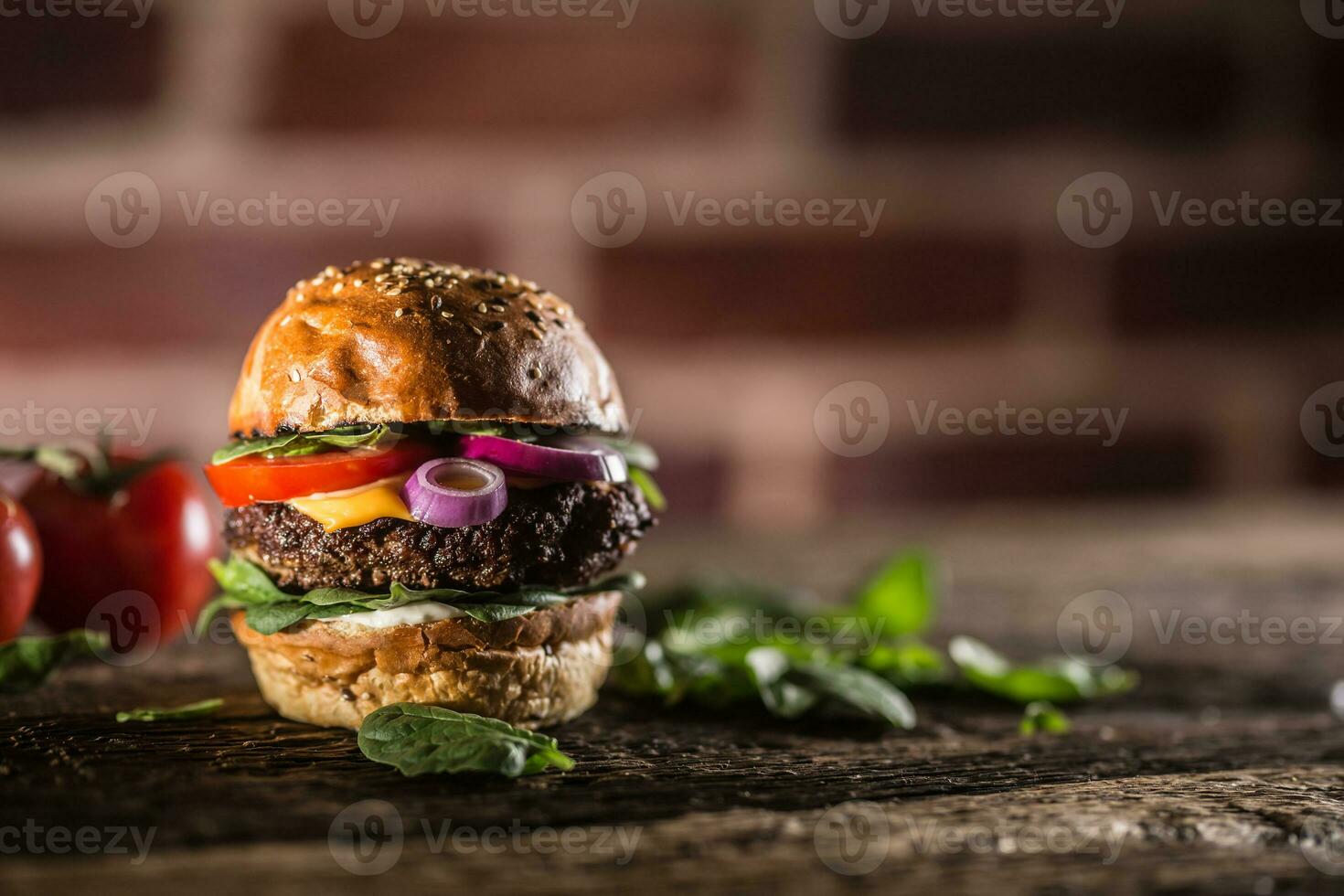 sabroso carne de vaca hamburguesa con Espinacas hojas ensalada cebolla tomate y queso foto