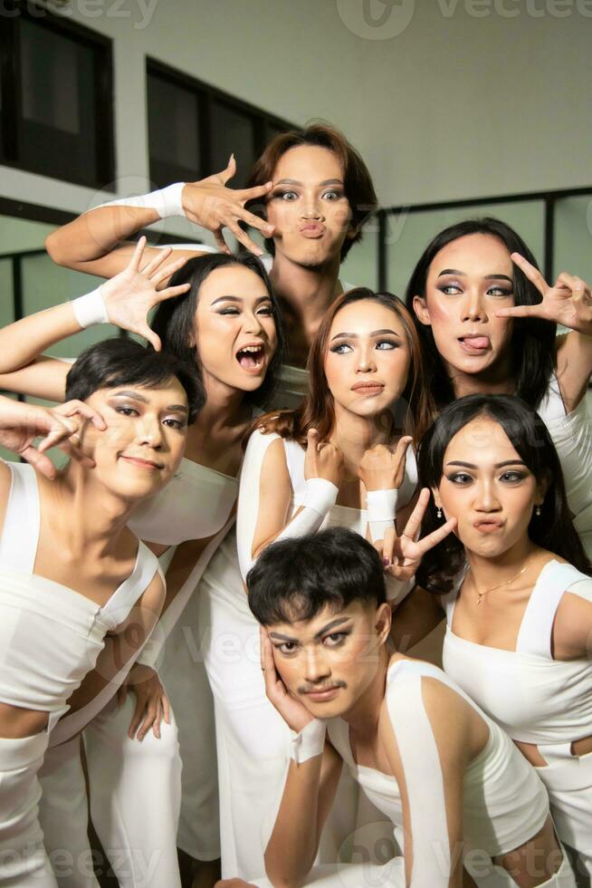 a group of Asian dancers get together and make silly faces while taking pictures on the dance floor photo