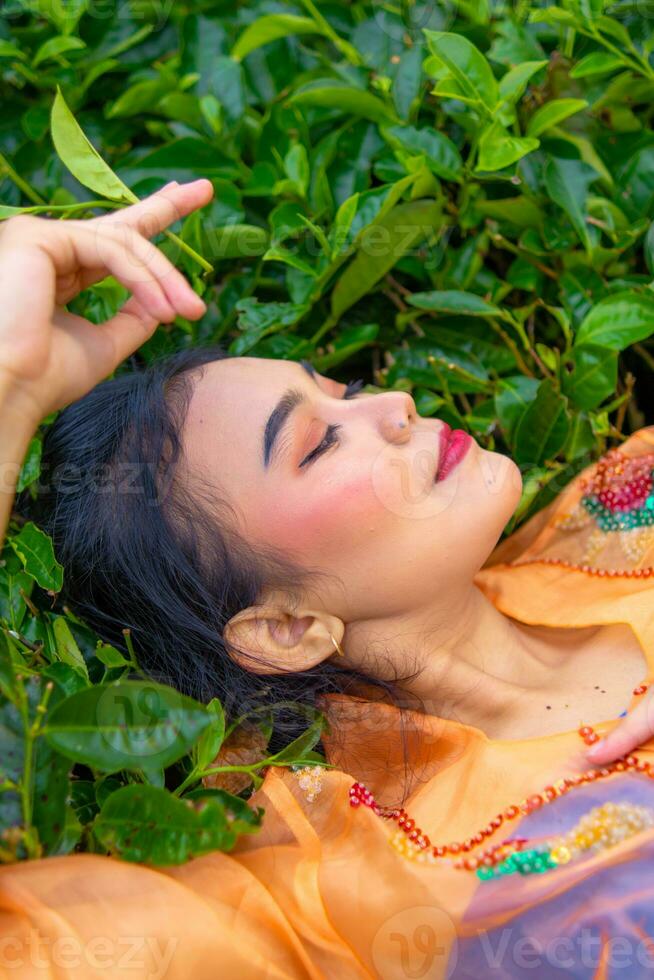 an Asian woman sleeping on green tea leaves photo