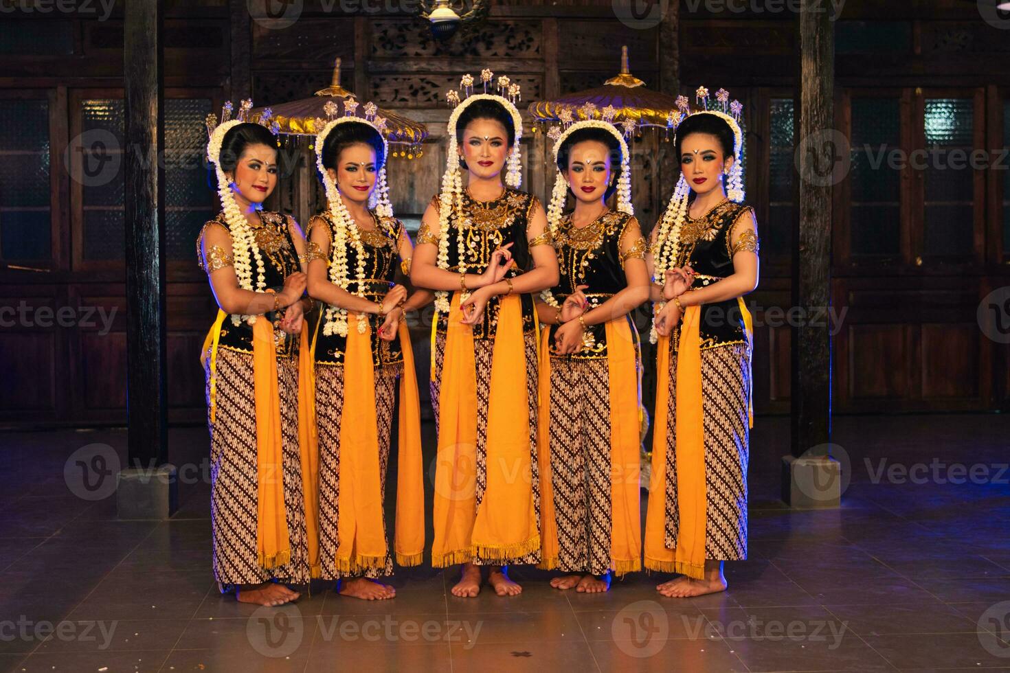 un grupo de javanés bailarines en pie con su amigos mientras vistiendo amarillo disfraces y chales foto