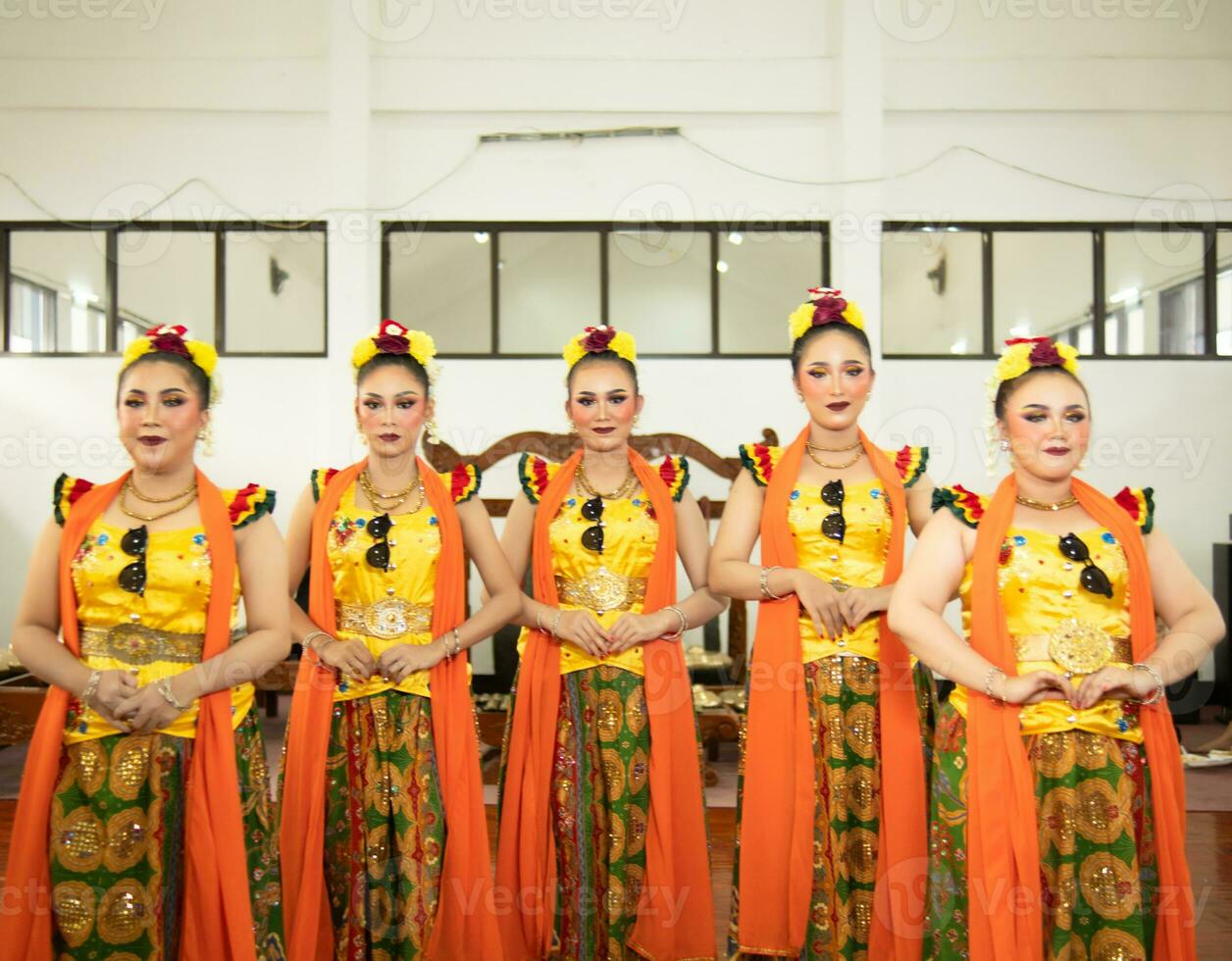 un grupo de tradicional sundanés bailarines en pie con su amigos antes de el actuación empieza foto