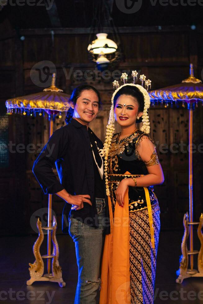 a Javanese dancer taking pictures with fans on stage photo
