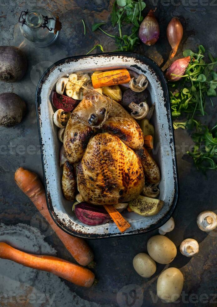 Roast whole turkey or  chicken in old pan with vegetables photo