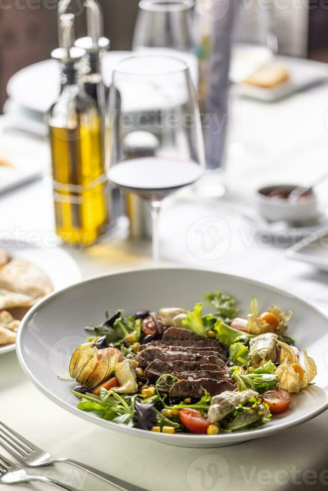 conjunto mesa con filete y ensalada con condimentos siguiente a eso en un restaurante foto