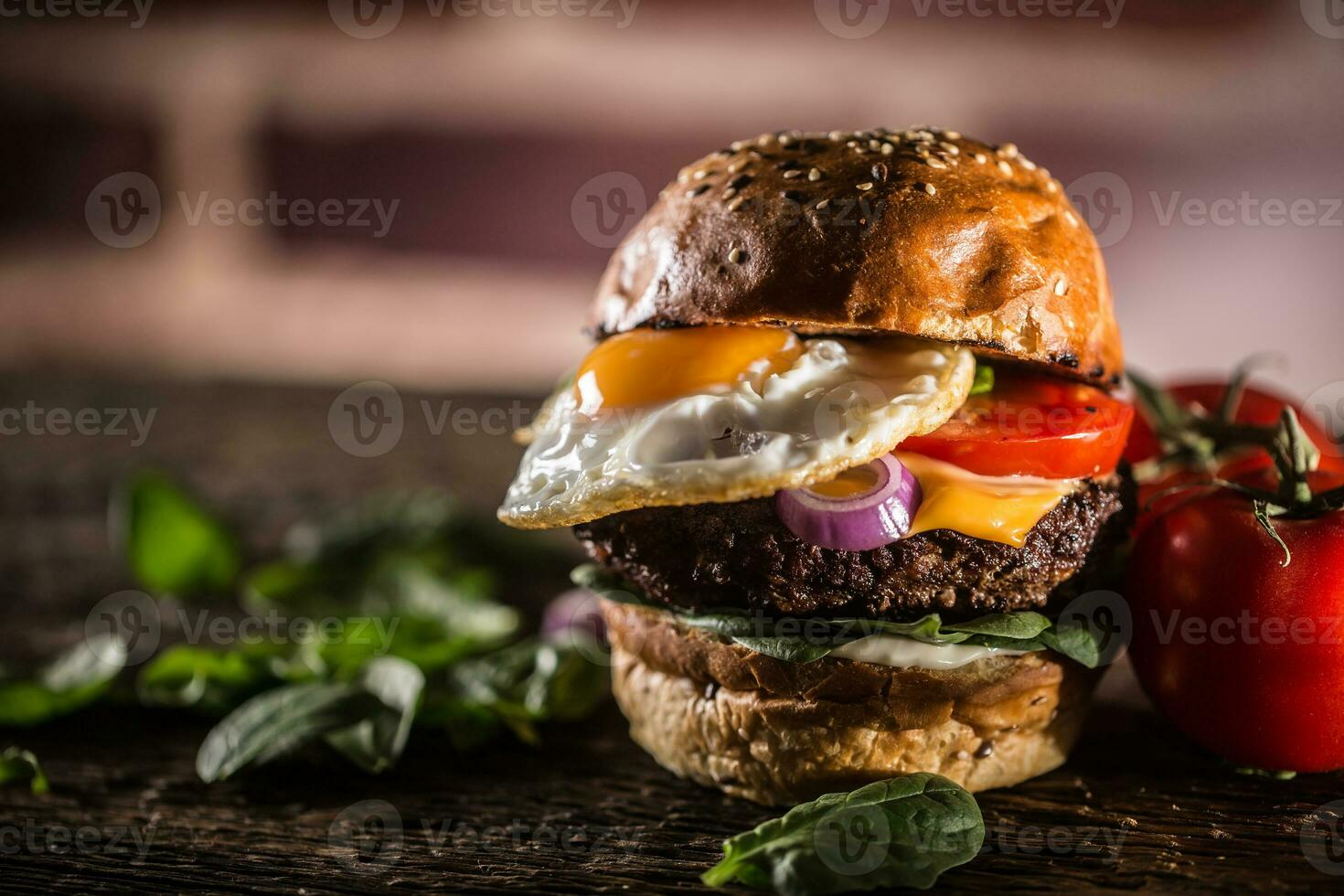 sabroso carne de vaca hamburguesa con Espinacas hojas ensalada cebolla tomate y queso foto