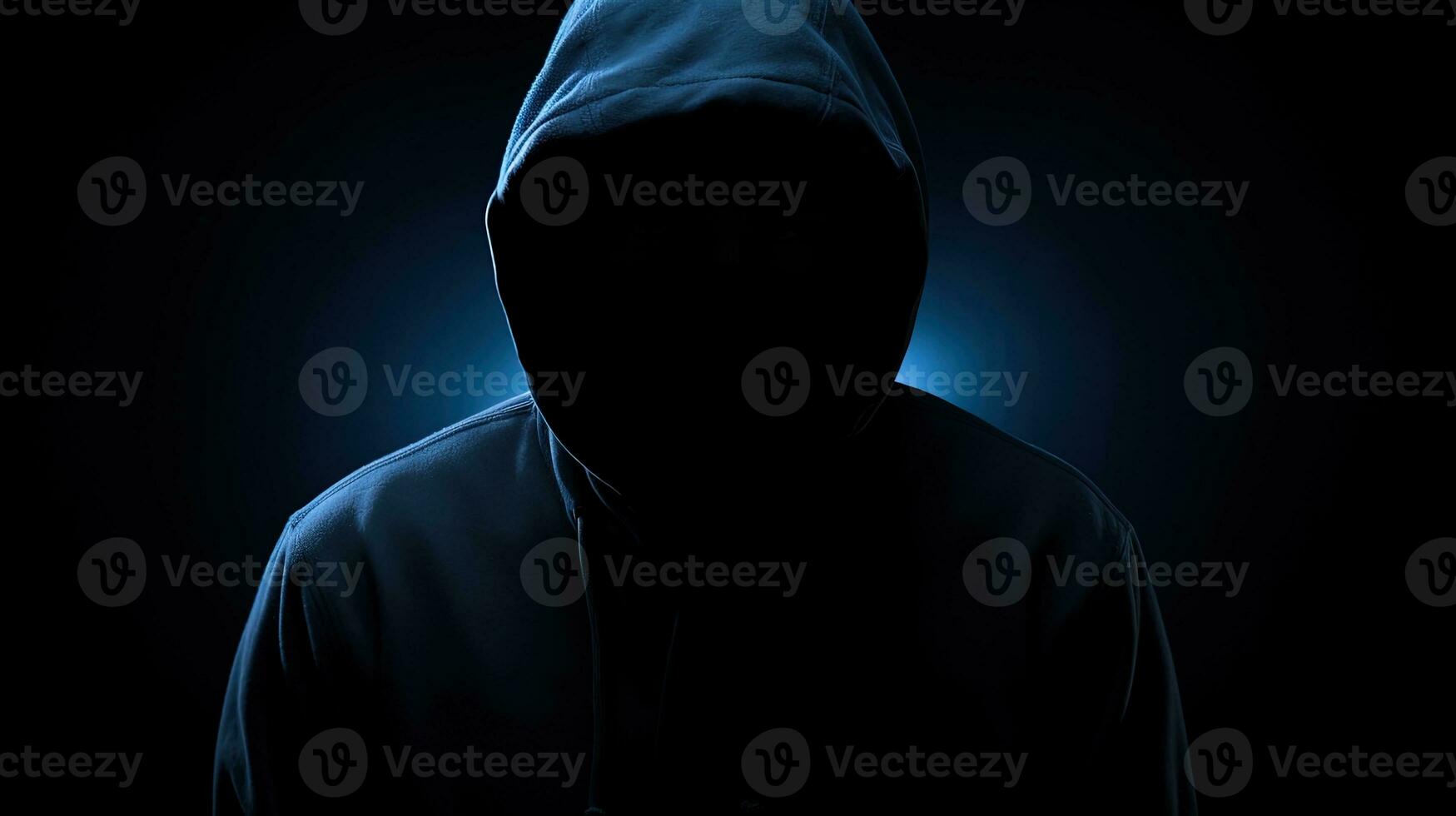 Unrecognizable figure in dark blue hoodie concealed face arms crossed solitary in darkness. silhouette concept photo