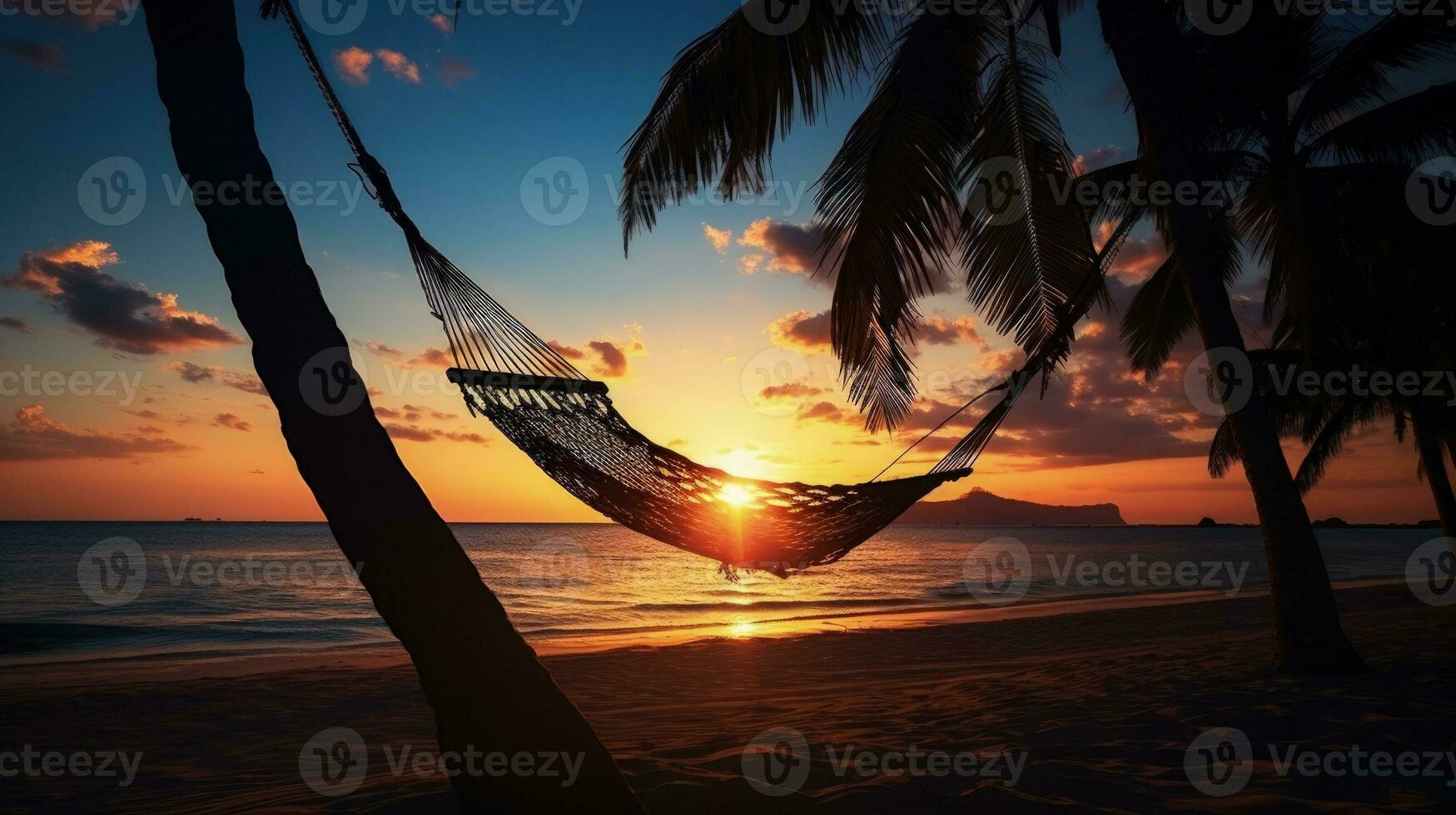 Gorgeous sunset over a tropical beach with palm trees and a hammock. silhouette concept photo