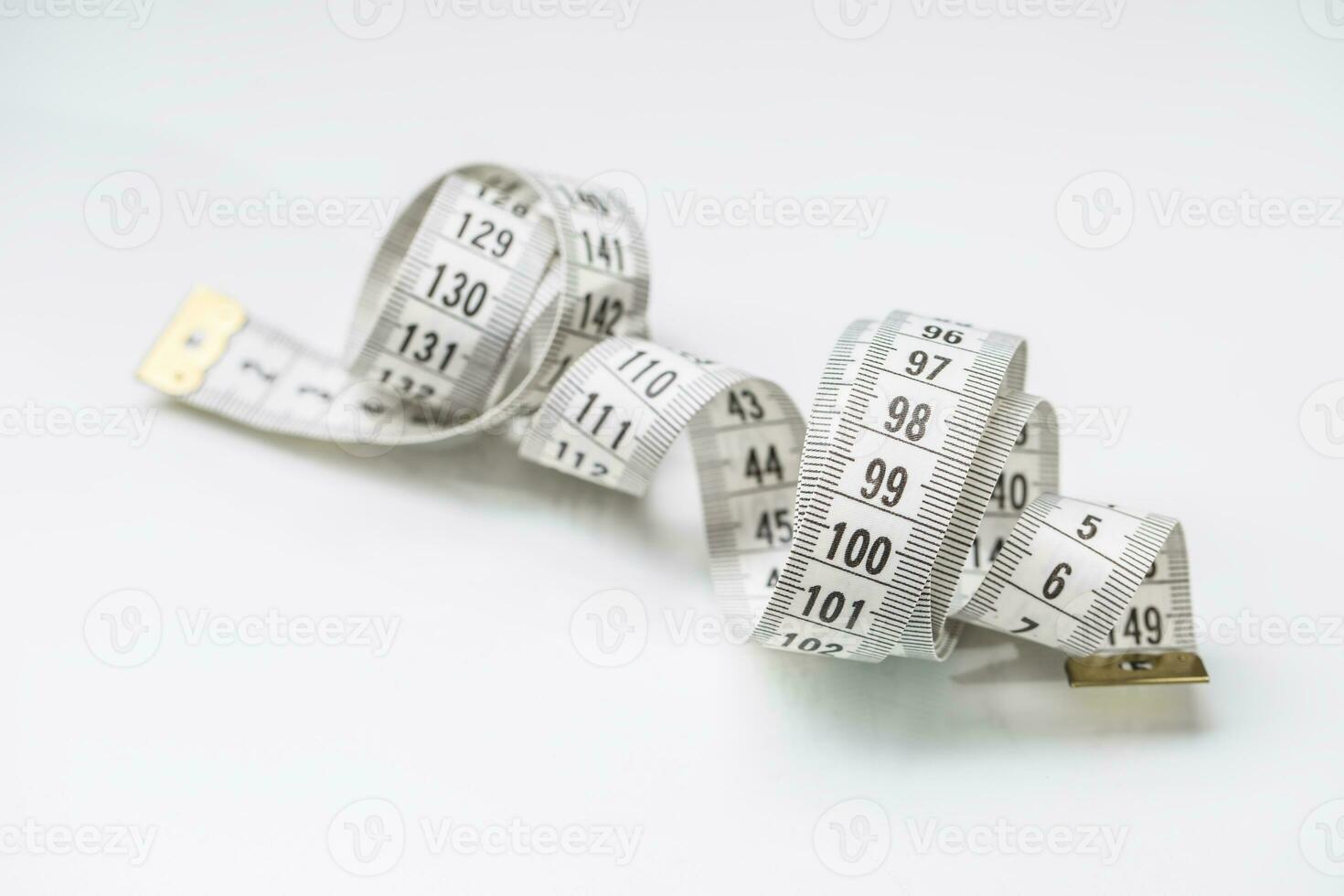 Curved measuring tape. Measuring tape of the tailor. Closeup view of white measuring tape photo