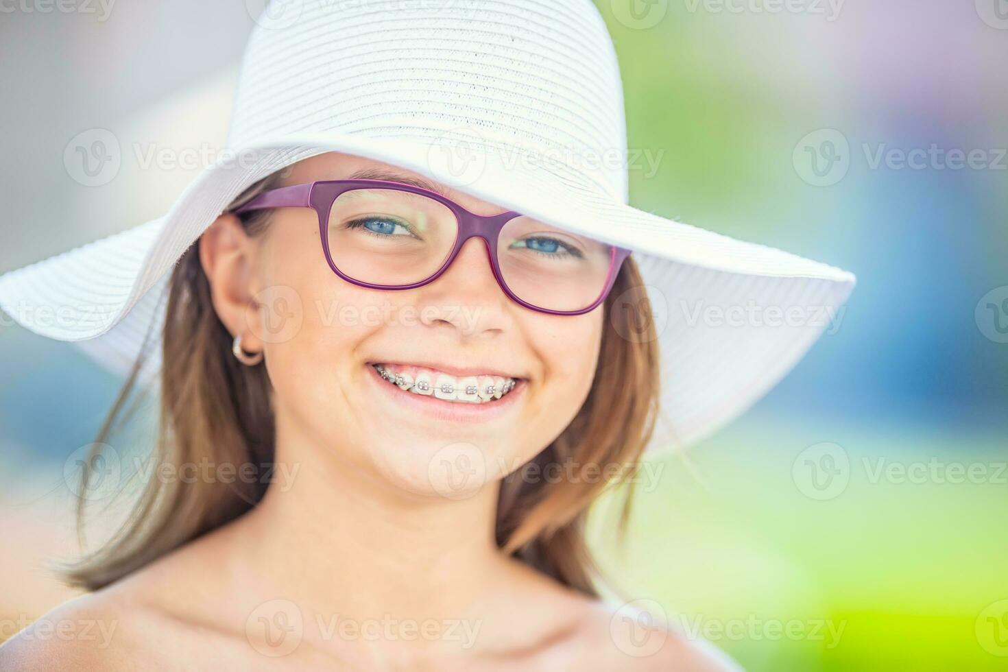 Happy smiling girl with dental braces and glasses.  Orthodontist and dentist concept photo