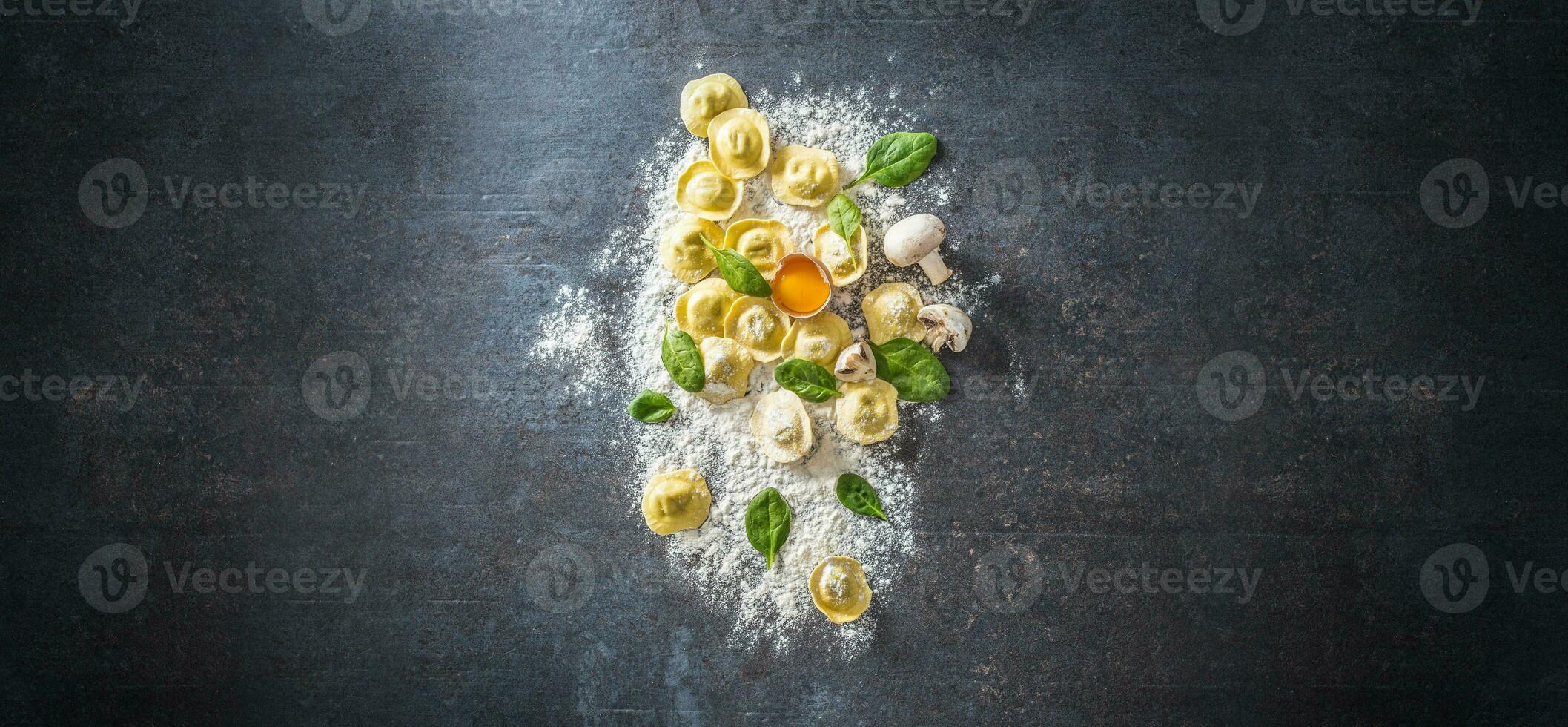 Raw ravioli with flour egg musrooms and and spinach - Top of view. Italian or mediterranean healthy cuisine photo